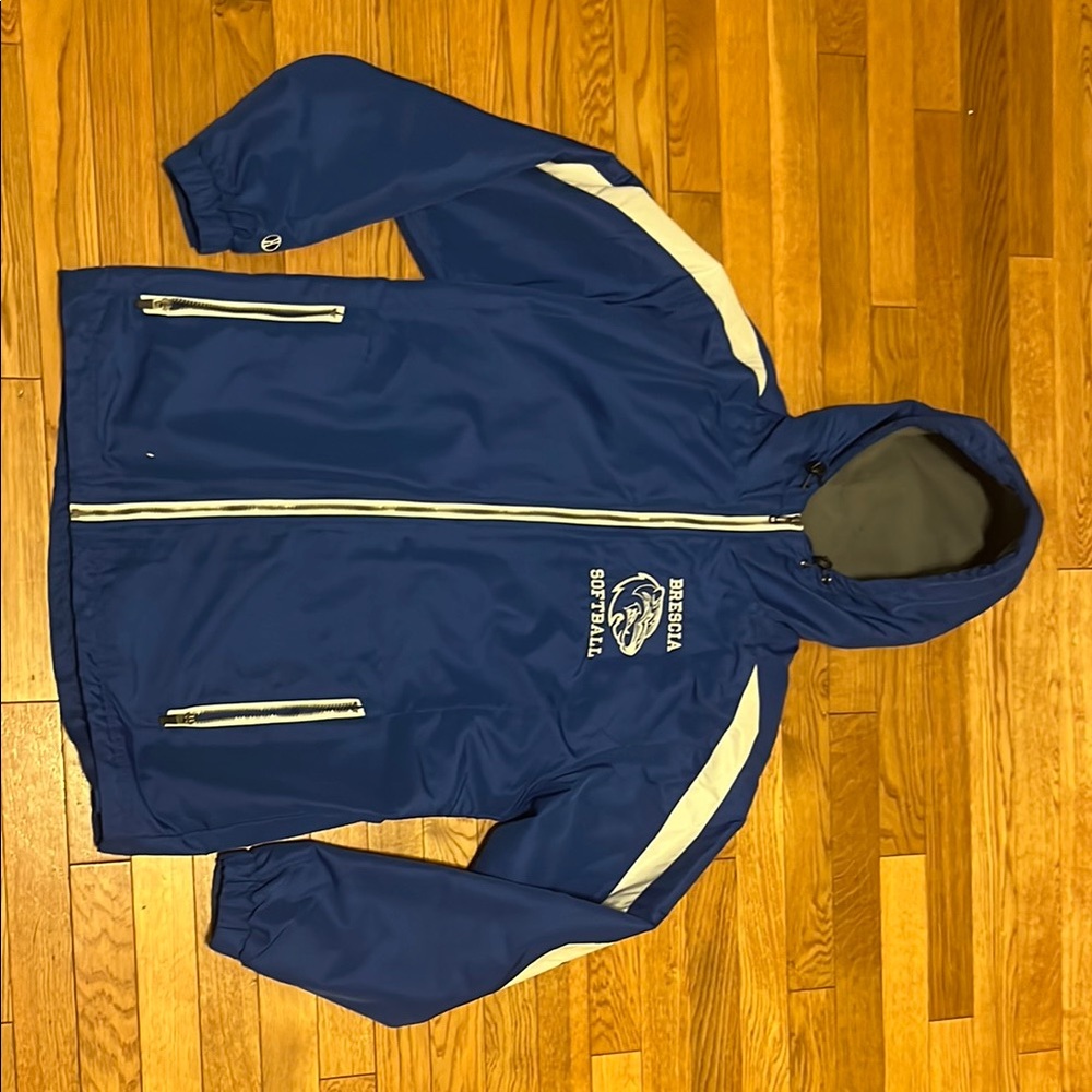Brescia softball college windbreaker blue with stripes along shoulders and arms.